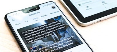 堆叠的报纸和笔记本电脑显示体育新闻网页